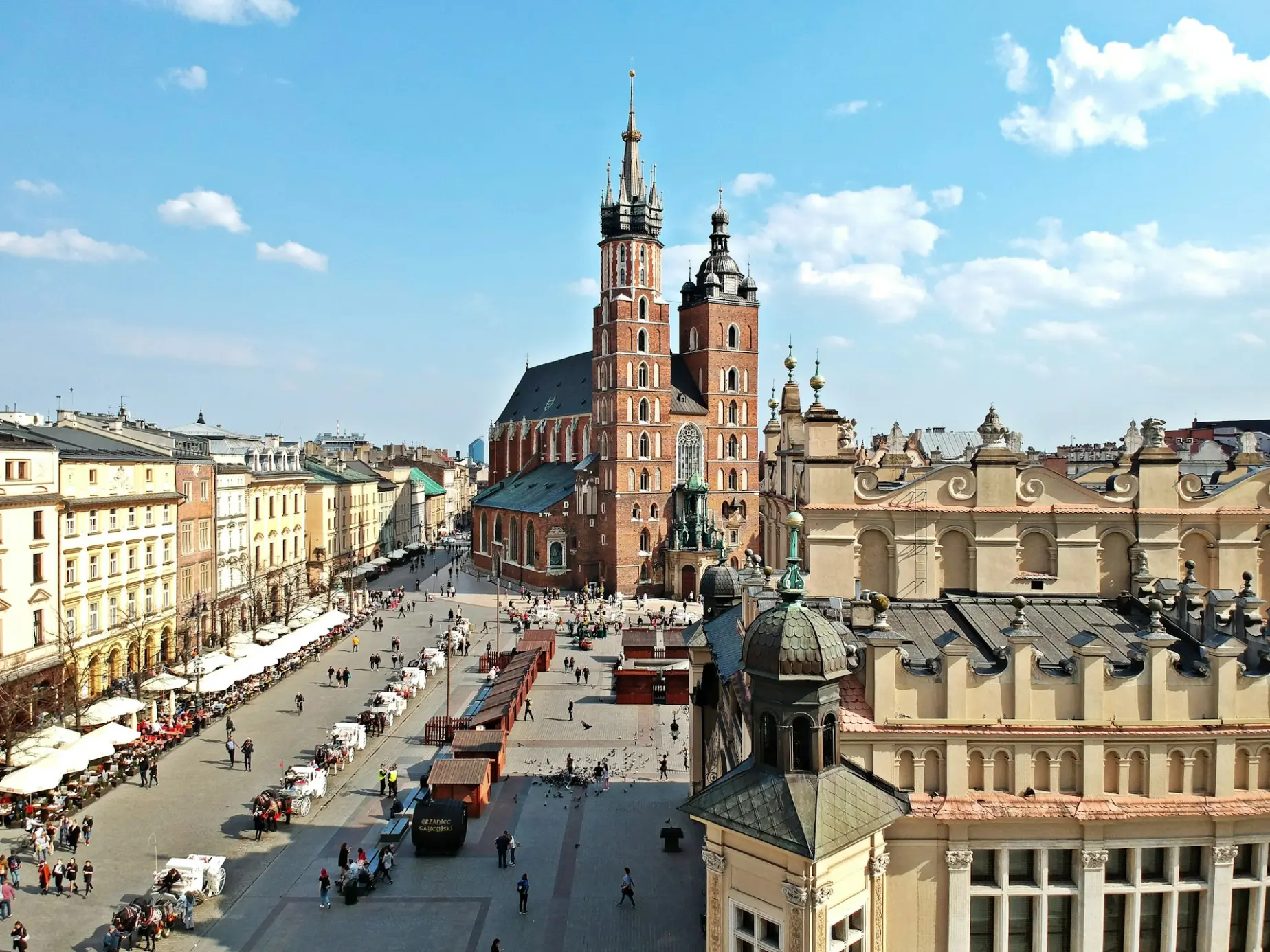 A view of a city square with a clock tower in the background