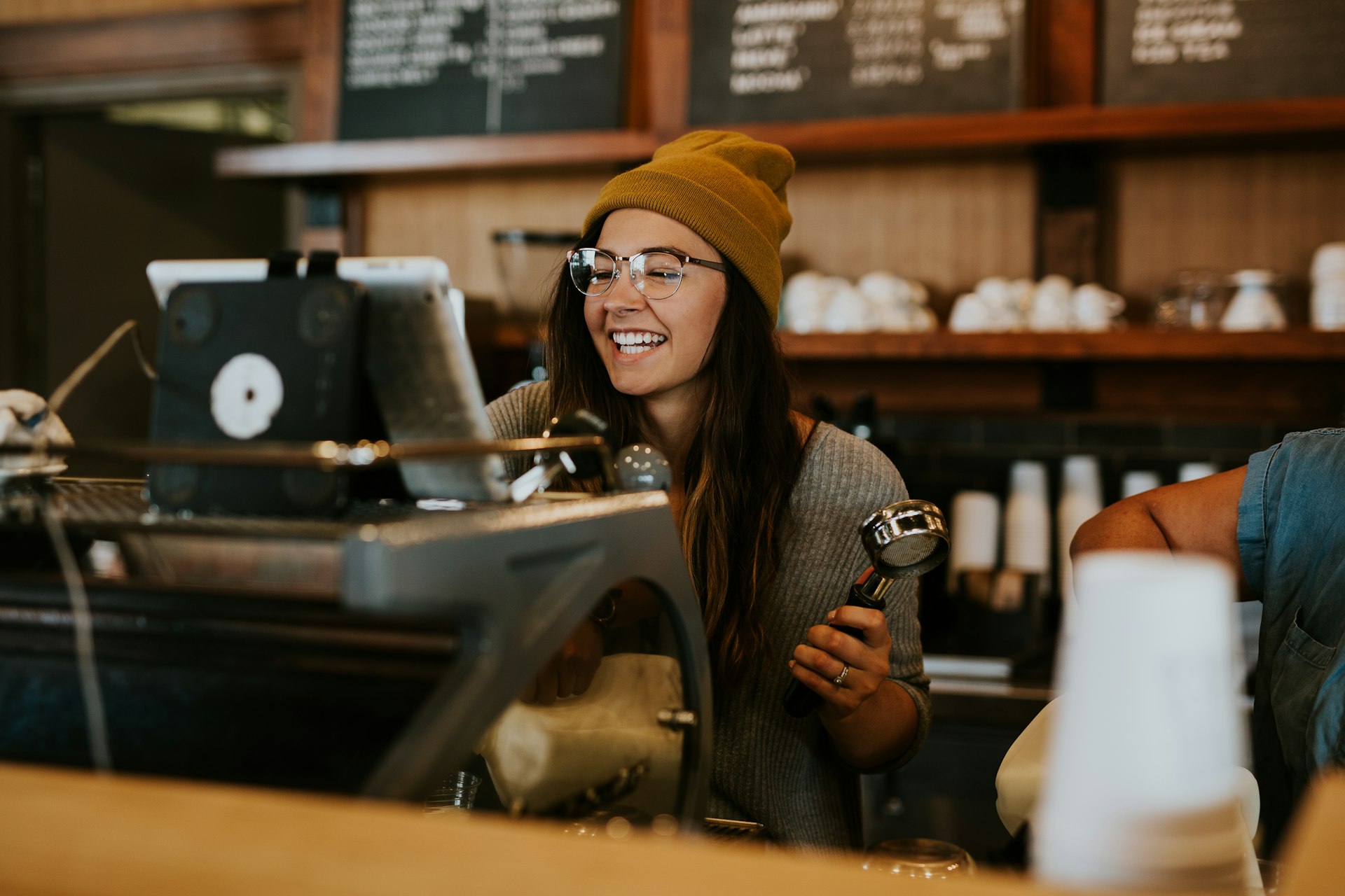 Female barista operating a coffee machine, representing small business founders entering the Polish market