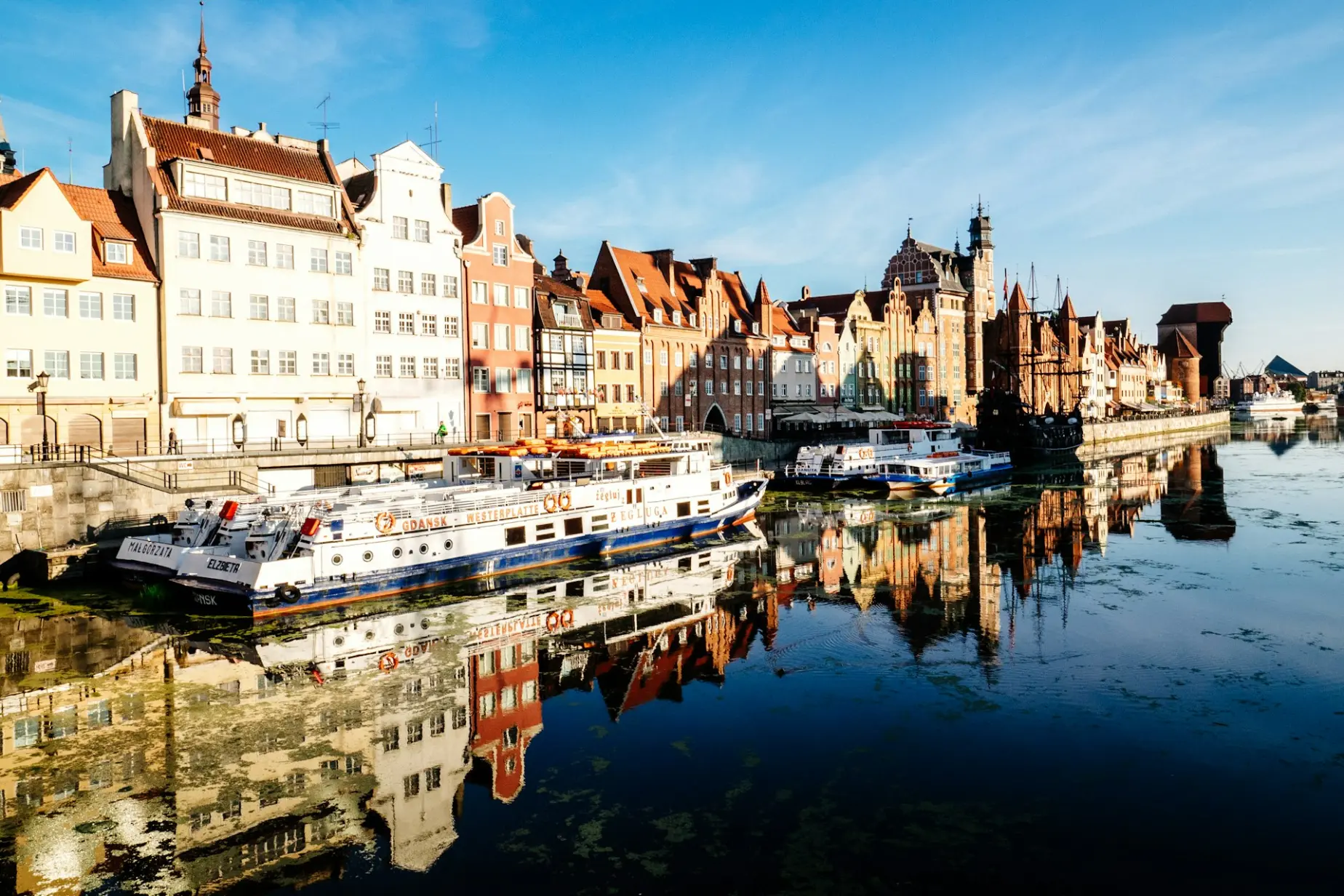 White and blue boat docked near buildings